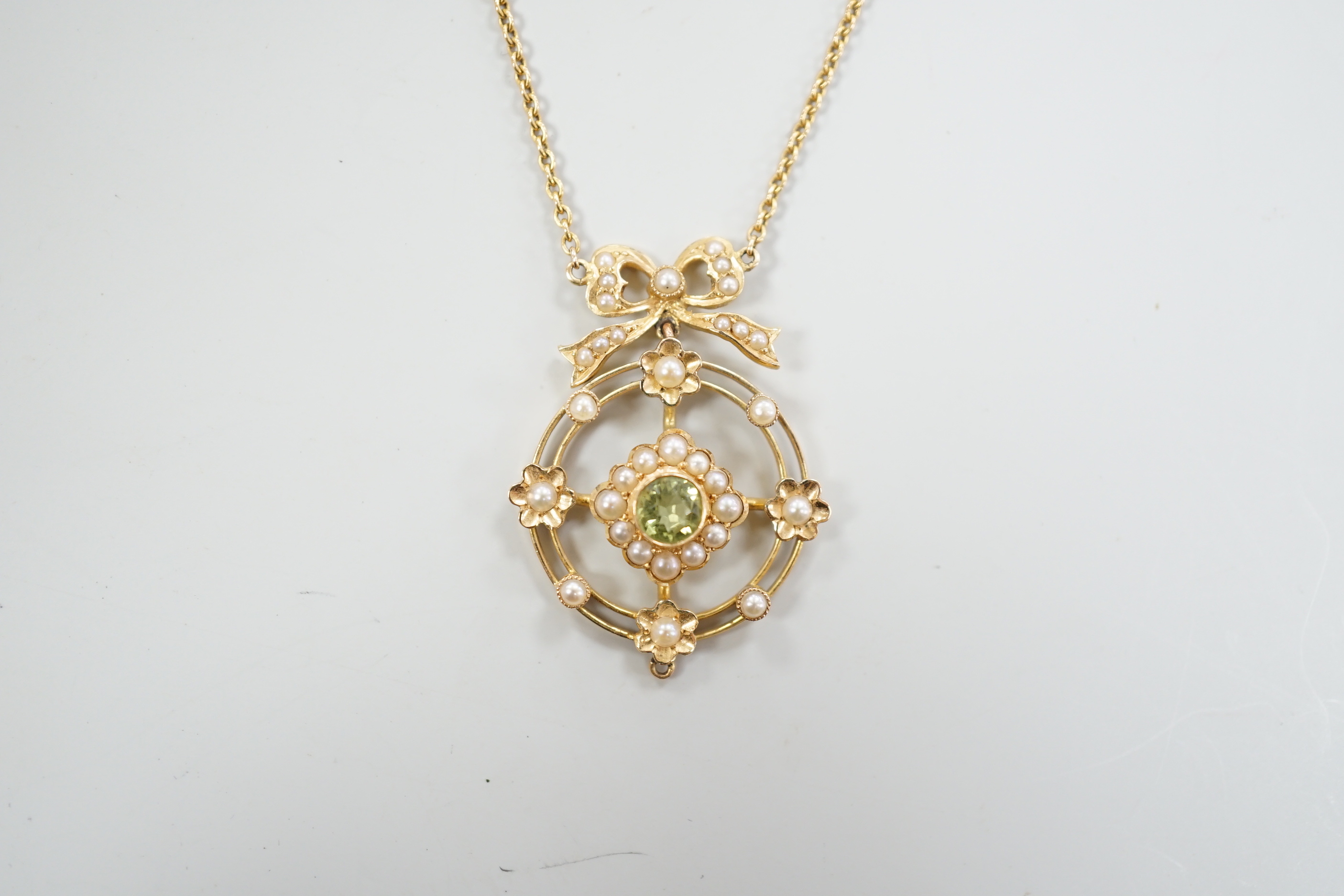 An Edwardian yellow metal, peridot and seed pearl cluster set pendant necklace, overall 55cm, gross weight 5.7 grams.